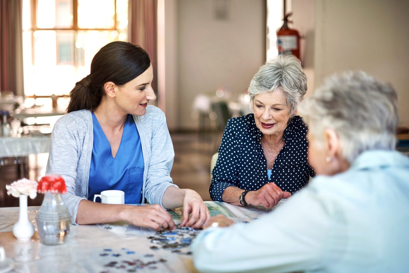 Caregiver working on a puzzle with senior clients